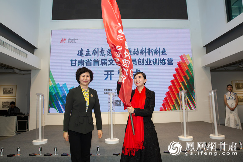 甘肃省人社厅党组书记、厅长周丽宁（左）为甘肃省首届文创人员创业训练营授旗 兰州文创产业园文化艺术交流中心供图