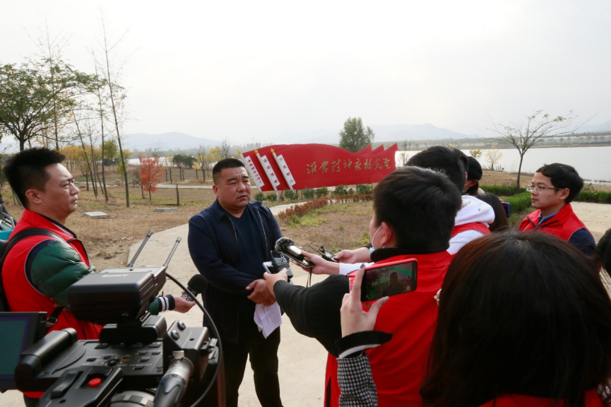 (石峰向记者讲述彩票路建成后石龙湾的变化)