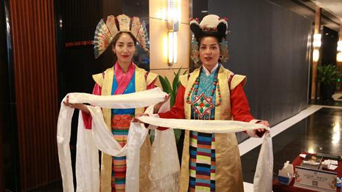 图为藏族姑娘向参会嘉宾献哈达