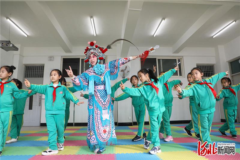 2020年11月19日，河北省唐山市京剧艺术团演员在唐山市丰润区迎宾路小学为学生示范戏曲动作。