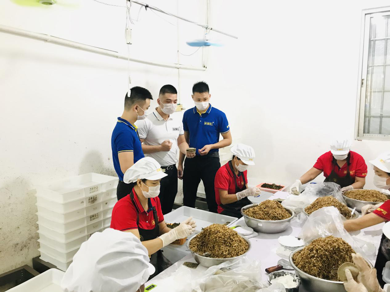 吴川市蒜鲜食品有限公司的工人们在熟练地制作田艾饼