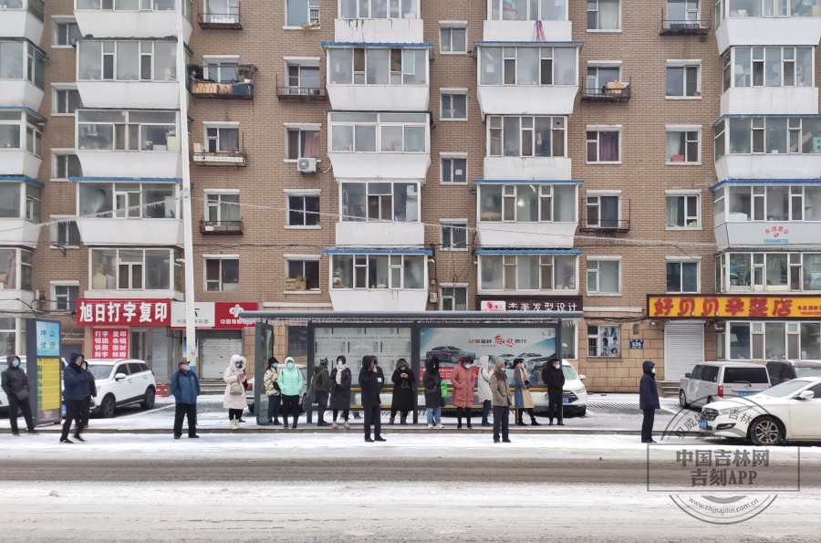 早高峰雪中等车的市民。