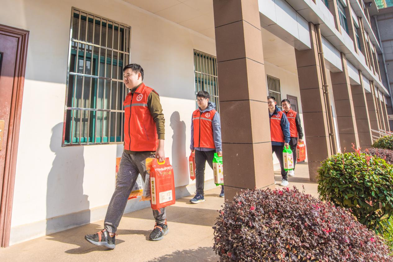 图为国网庐江县供电公司共产党员服务队队员为公司消费扶贫采购活动搬运农副产品。