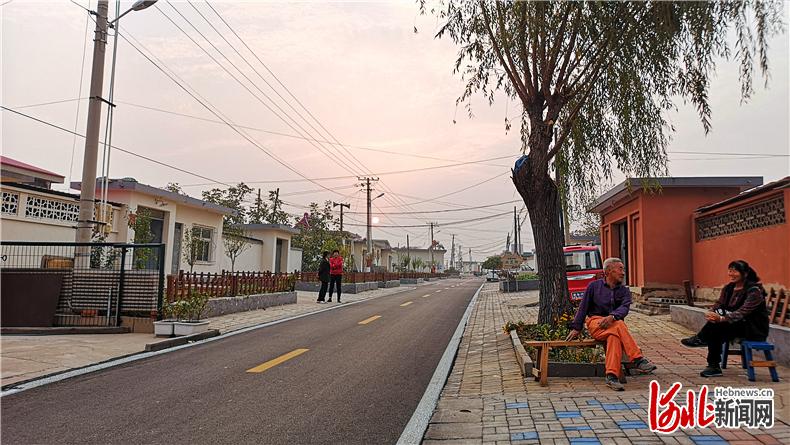 日前，山海关区石河镇古城村“美丽庭院中心户”户主张宝全（前左）与邻居畅聊美好生活。在全区农村环境评比中获得“五星级村庄”称号的古城村，在落日余晖中透着静谧闲适的气氛。河北日报记者师源摄
