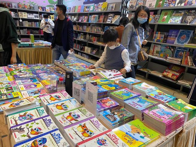 中国上海国际童书展现场，一位小读者专心翻看一本英语原版童书。新华社记者王婧媛 摄