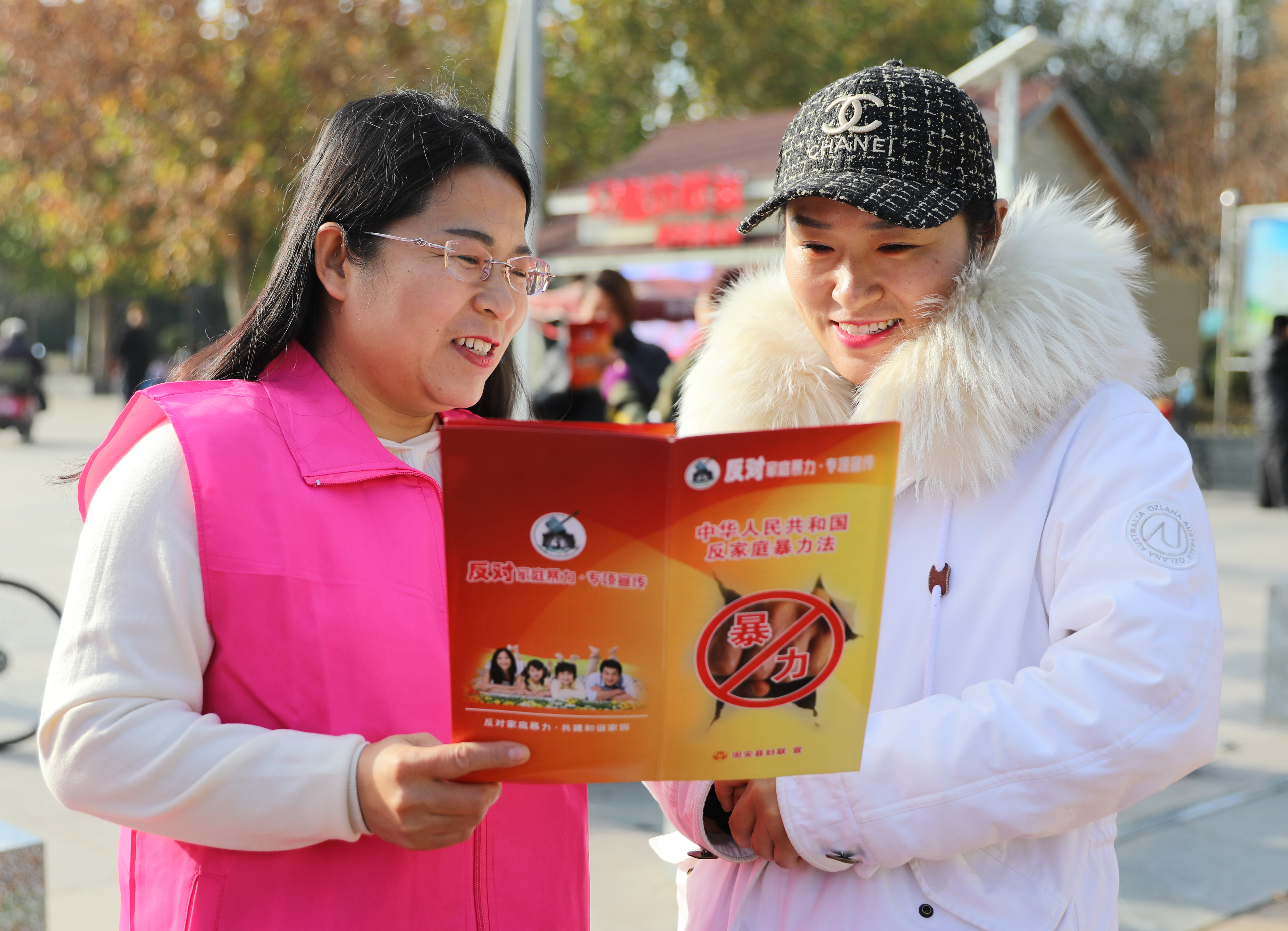 11月24日，在固安县人民广场，妇联志愿者向群众宣传反对家庭暴力知识。