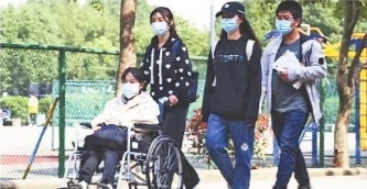 同学推着轮椅送董子涵上课。