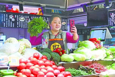 武昌沙湖一菜市场，90后摊主小李正通过网络直播卖菜。