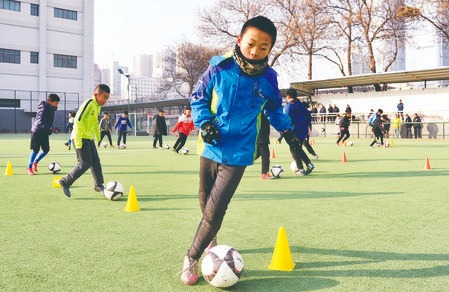 南河小学的孩子们在操场上进行足球训练