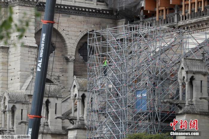 资料图：当地时间2020年6月17日，法国巴黎，工人拆除巴黎圣母院被烧毁的脚手架，并安装新的脚手架。