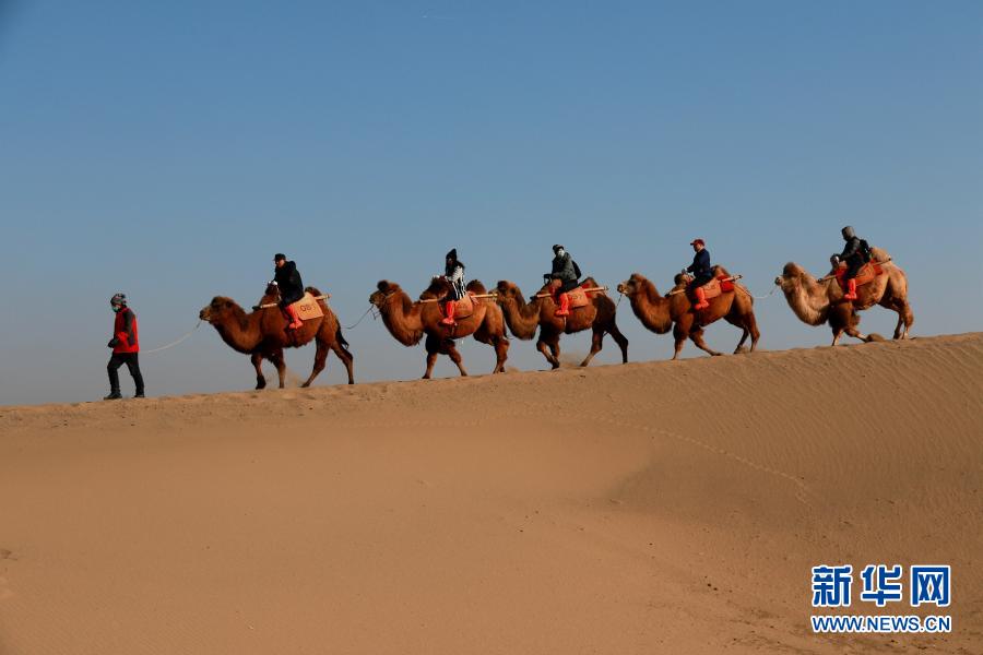 12月1日，游客在甘肃省敦煌市鸣沙山月牙泉景区游览。新华社发 张晓亮 摄