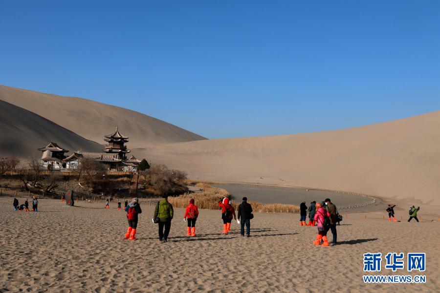 12月1日，游客在甘肃省敦煌市鸣沙山月牙泉景区游览。新华社发 张晓亮 摄