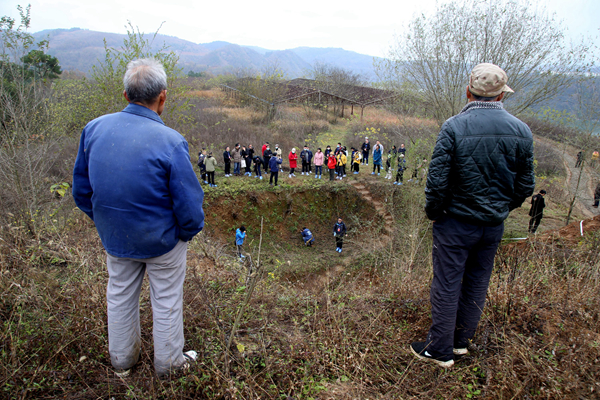 2020年11月26日,专家、学者们在湖北省十堰市郧阳区青曲镇弥陀寺村学堂梁子参观“郧县人”遗址,引起当地群众围观