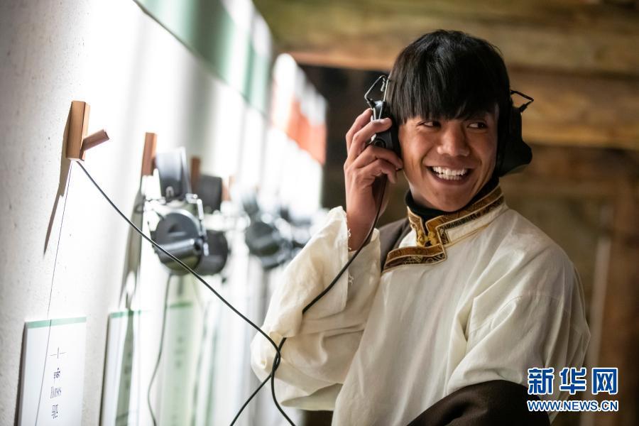 在理塘县勒通古镇的喜马拉雅之声微博物馆，丁真拿起耳机听马匹的声音（12月2日摄）。在这个微博物馆，游客可以体验藏族传统乐器，聆听马蹄声等声响，观看藏族传统音乐相关的视频。当地通过老城区改造等一系列措施，打造出著名景区“千户藏寨”，包括勒通古镇、仁康古街、长青春科尔寺等，集中展现理塘的历史文化魅力。这里将成为丁真未来的工作场所之一。