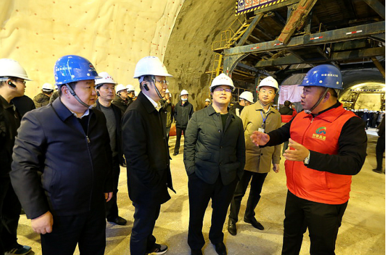 李芸（右一）在隧道掌子面向交通厅副厅长刘震华（中）介绍隧道地质情况