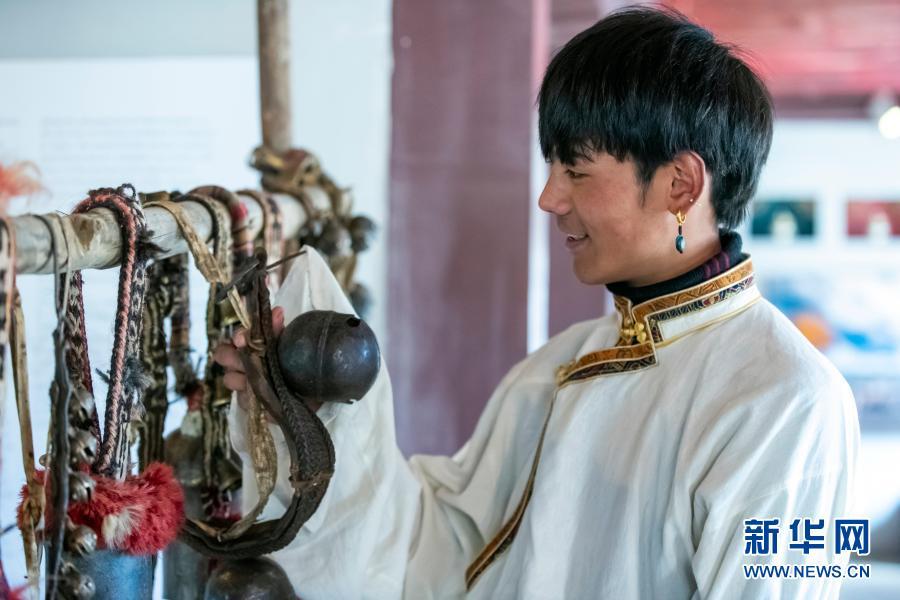 在理塘县勒通古镇的喜马拉雅之声微博物馆，丁真拨动当地传统的一些用具、器物，如铜铃、马鞍等，聆听它们发出的声响（12月2日摄）。在这个微博物馆，游客可以体验藏族传统乐器，聆听马蹄声等声响，观看藏族传统音乐相关的视频。当地通过老城区改造等一系列措施，打造出著名景区“千户藏寨”，包括勒通古镇、仁康古街、长青春科尔寺等，集中展现理塘的历史文化魅力。这里将成为丁真未来的工作场所之一。