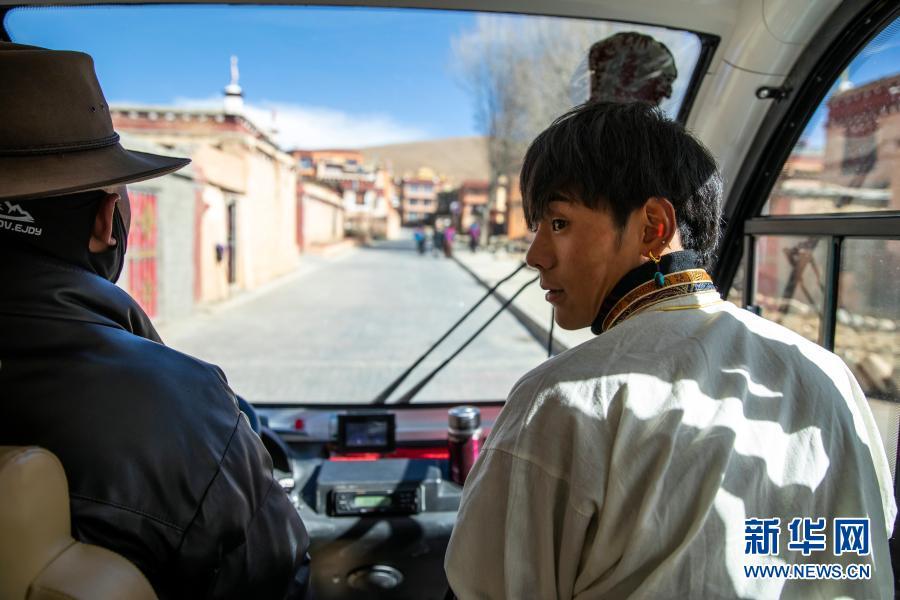 在理塘县勒通古镇，丁真（右）乘坐旅游摆渡车前往一个微型博物馆以熟悉自己未来的工作场所（12月2日摄）。