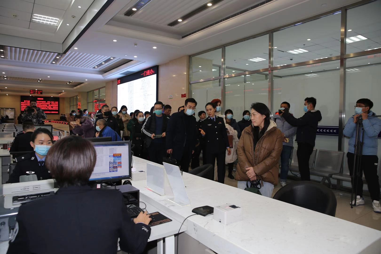 图为与会代表参观出入境办证服务大厅