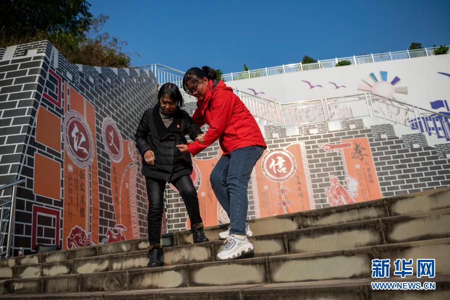 一名老师搀扶张桂梅（左）下台阶（11月30日摄）。新华社发（陈欣波 摄）