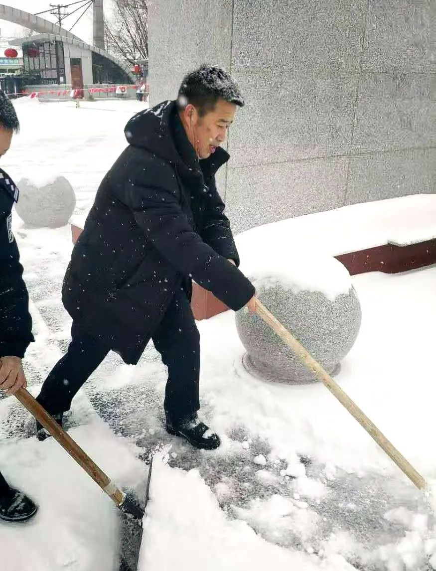 图为赵殿君主任封闭执勤期间与民警一起清雪