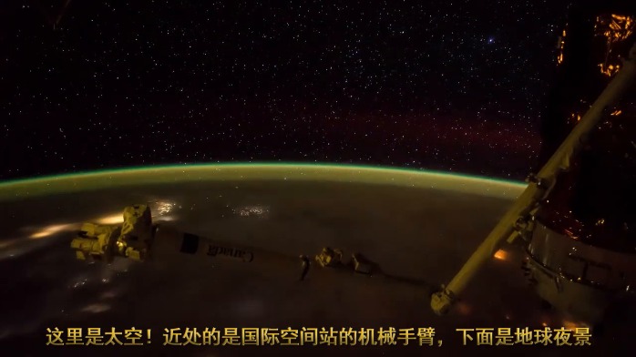 这里是太空，近处是国际空间站的机械手臂，下面是地球夜景