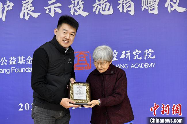 12月11日，敦煌研究院榆林窟保护展示设施捐赠仪式在榆林窟举行。敦煌研究院名誉院长樊锦诗(右)先生向国强公益基金会颁发了捐赠证书。敦煌研究院供图