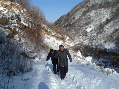 大雪皑皑,西安市机关事务局帮扶干部在入村路上