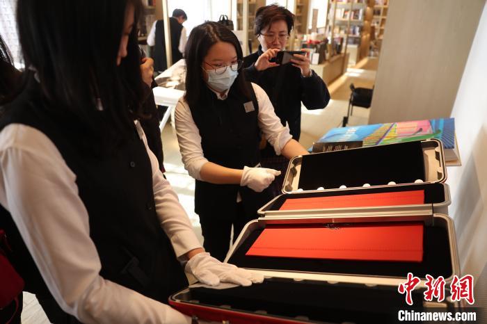 工作人员打开镇店图书——价值39万的法拉利纪念图册 张亨伟 摄