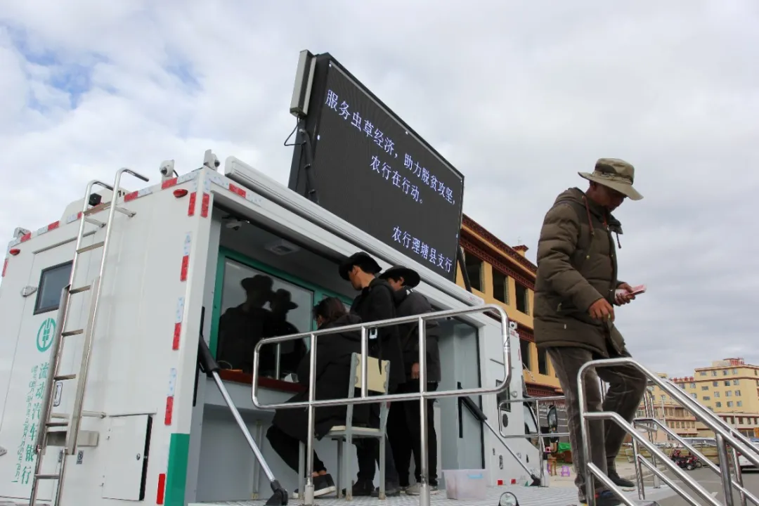 四川理塘的牧民和虫草商贩正在农行的流动汽车银行办理业务