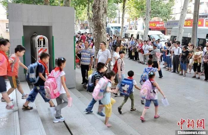 资料图:武汉一小学门外等待学生放学的家长们.中新社发 张畅 摄