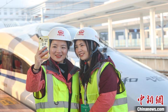 参与京港高铁安九段建设的中铁四局工作人员在列车前合影。　刘力鑫 摄