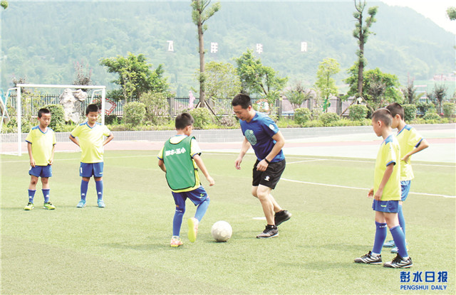彭五小老师在指导学生踢足球。