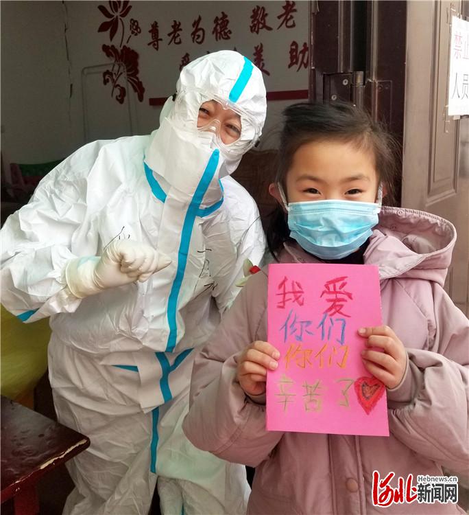 1月12日，石家庄市桥西实验小学二年级10班学生赵一迪，在做完核酸咽拭子采集后，向医务人员送上自己的画，表达谢意。河北日报记者 赵永辉摄