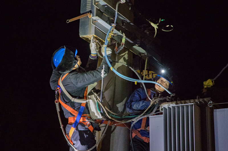 图为电力工作人员正在进行电力检修.
