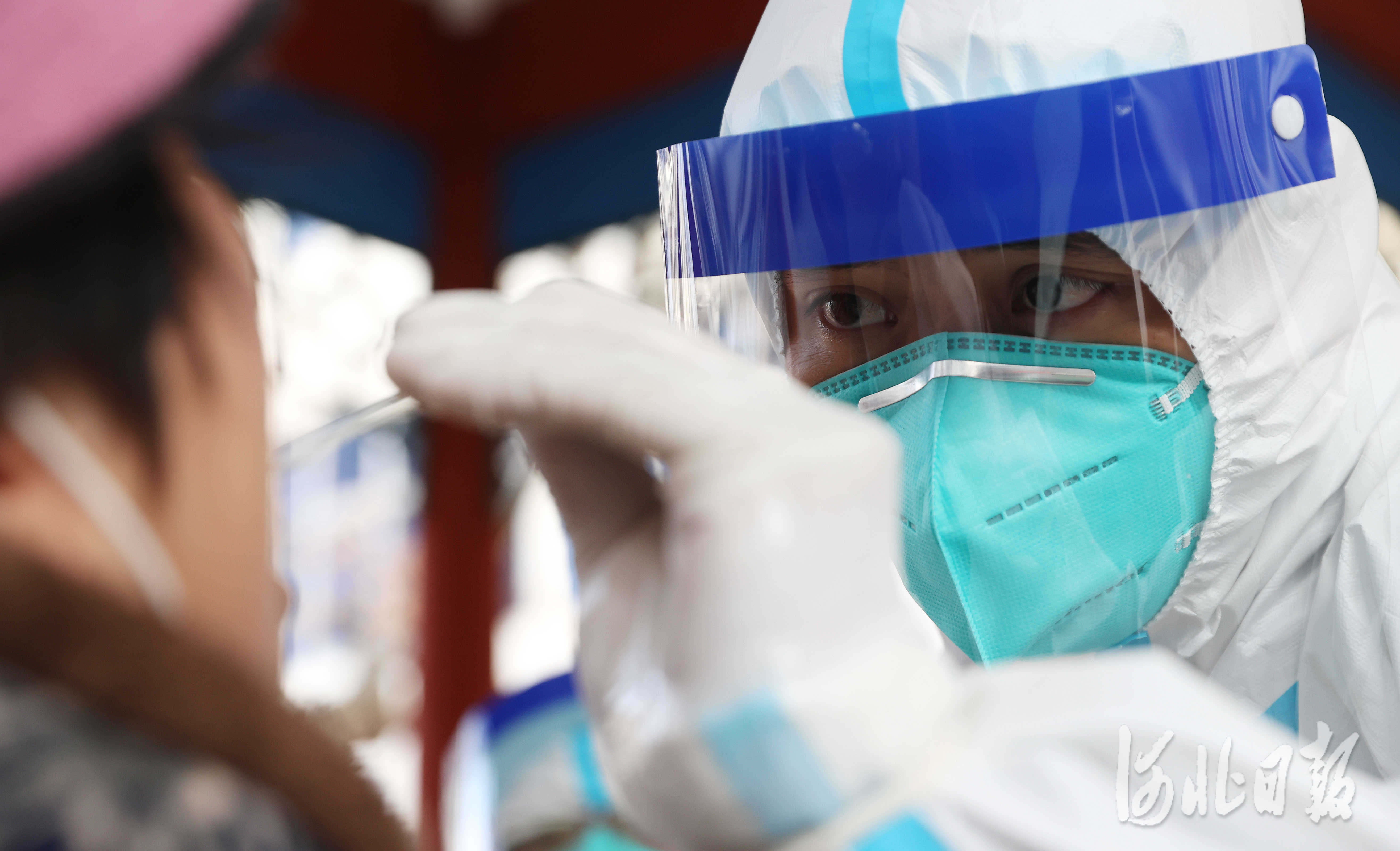 2021年1月12日,来自广东深圳的核酸检测服务队的采样人员邹奇给石家庄