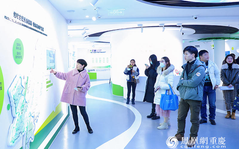 相关负责人介绍北碚新时代生态文明实践中心的宣传墙面。