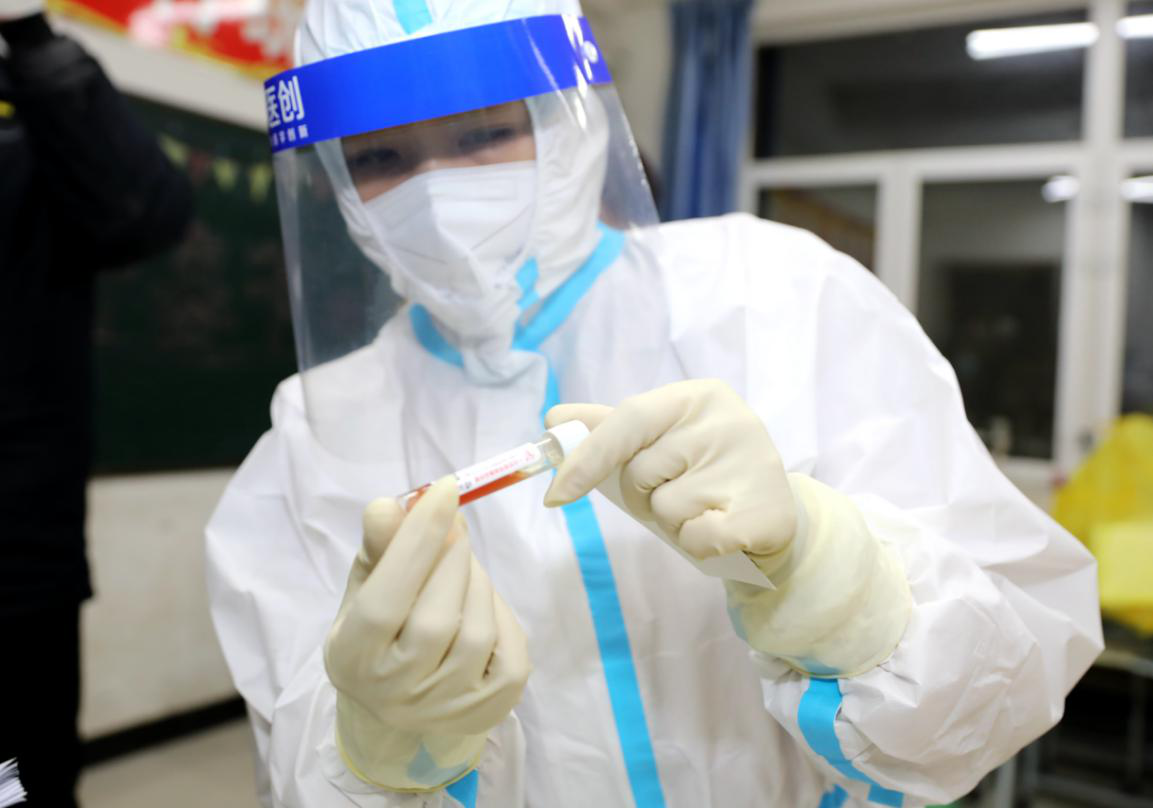 在固安县东湾乡苏桥中学核酸检测采集点，医护工作者正准备相关医疗物资。