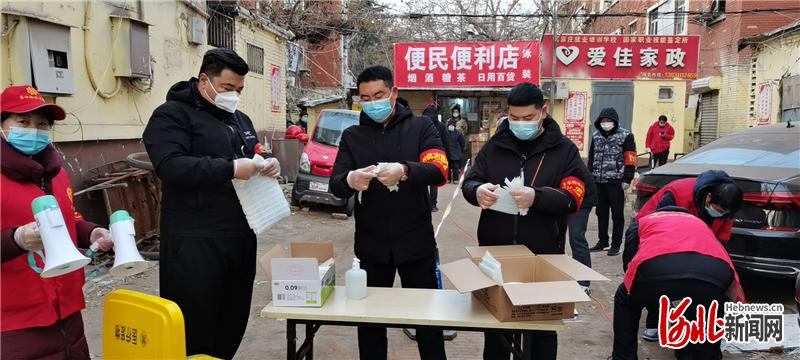 1月12日，李瑶（左三）在石家庄市桥西区东华街道办事处东马路社区内协助工作人员开展核酸检测志愿服务。河北日报通讯员苏亚兰摄