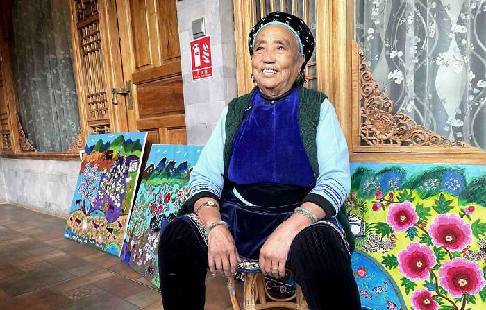 图为“农民画家”王秉秀坐在她的油画作品前。　缪超 摄