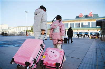 1月28日，在西安火车站，一对母女准备进站乘车。记者翟小雪 实习生朱媛君 摄