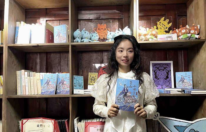 图为白族少女杨冬儿与她的《苍山小册子》。　缪超 摄