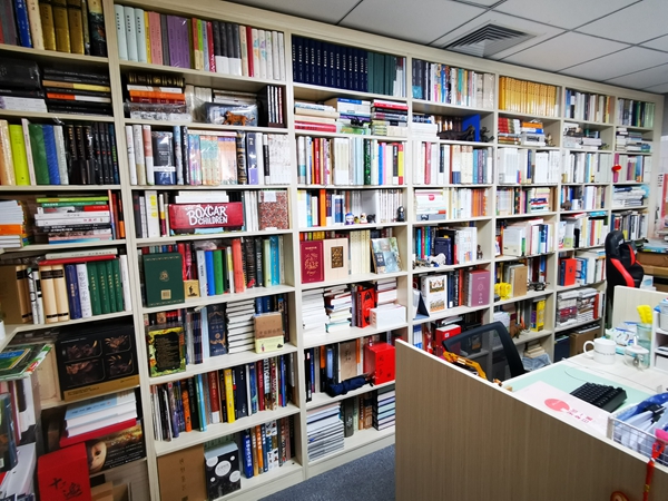 张亮办公室的书墙，是他十年间买买买的部分成果。