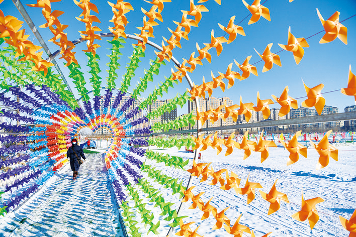 雪后的长春，晴空万里，白雪映衬下的长春天空格外蓝，南溪湿地公园呈现出一幅幅美景。图为市民从彩色的风车长廊走过。