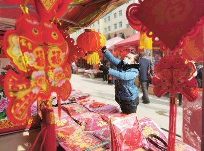 2月3日，春节临近，居民在康县城区滨河路年货市场挑选灯笼。本报通讯员 黄培军 摄（陇南日报）