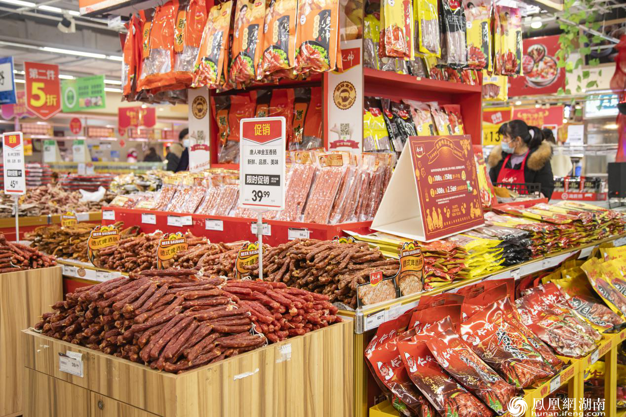 华润万家超市年货腊味整齐摆放,推出不少促销.郭菲尔 摄