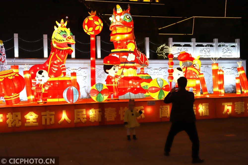 ↑2021年2月3日，甘肃省平凉市崆峒区宝塔广场，市民在迎春彩灯前拍照。CICPHOTO/吴希会 摄