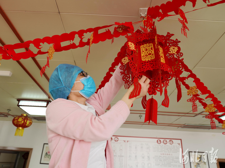 2021年2月10日，在河北省邢台市巨鹿县福缘居医养中心，护工在挂大红灯笼。