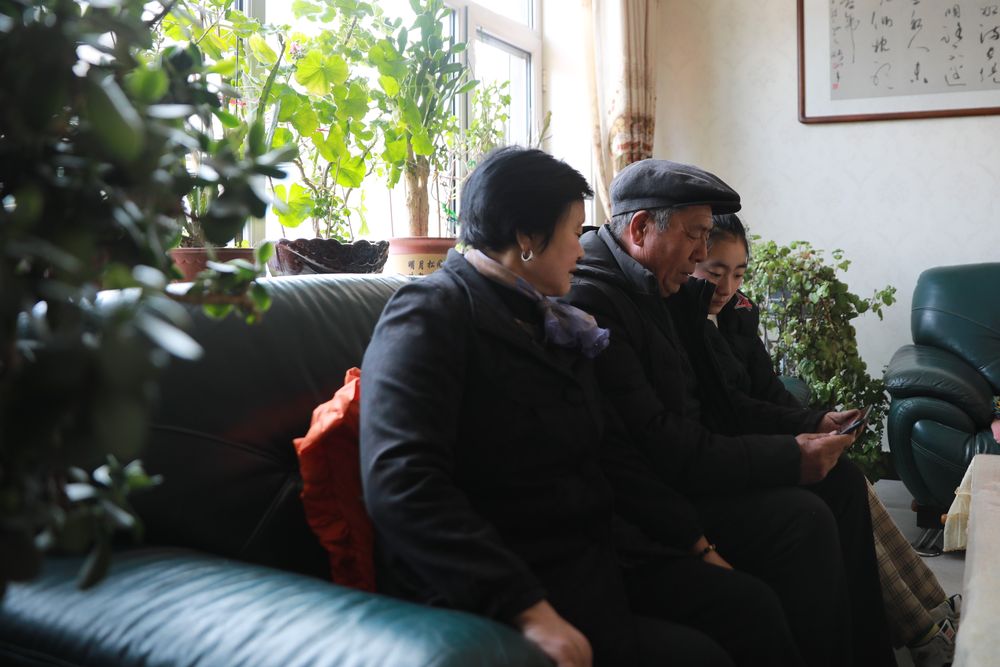 2月6日，静宁县城关镇东关村村民王胜利（中）和家人通过手机观看迎新春送欢乐网络文艺演出直播。