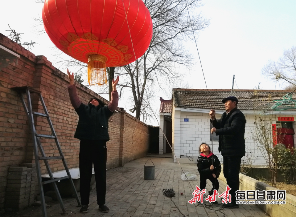小孩和爷爷奶奶一起挂大红灯笼 金奉乾摄