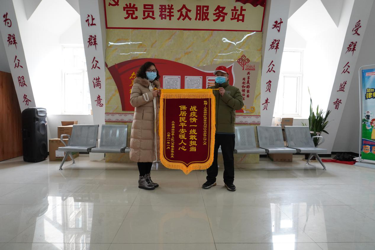 居民自发送给刘文勇（右一）和社区居委会的锦旗 供图 众美城